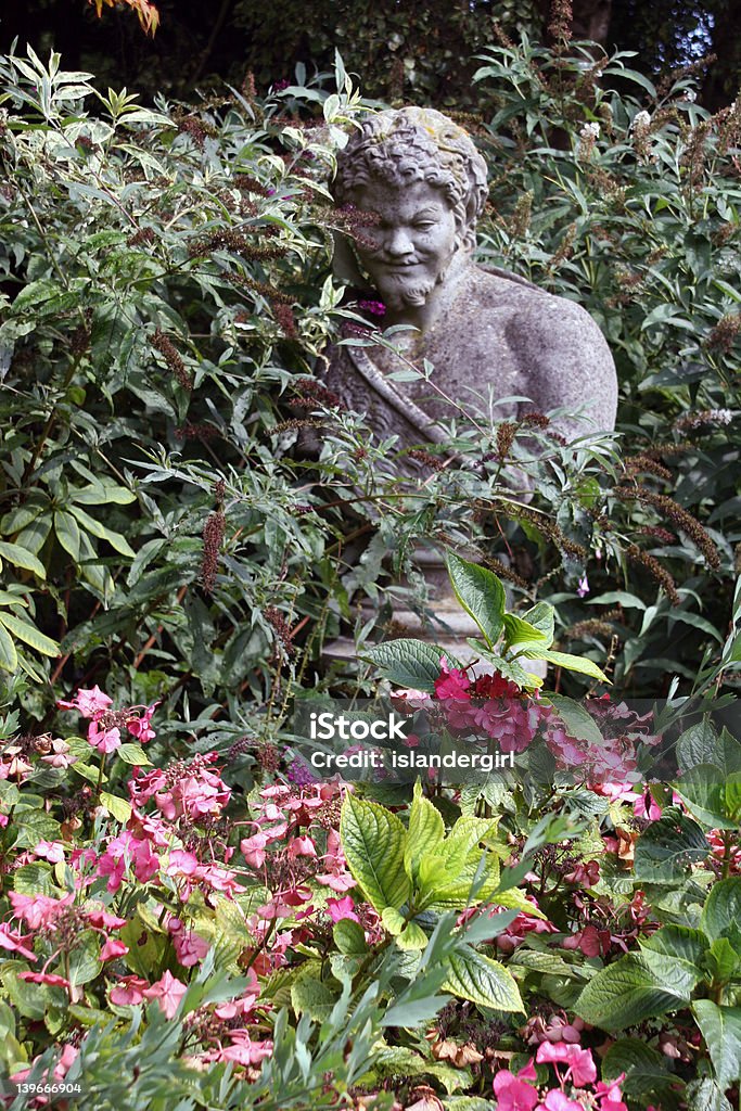 Statua nel giardino tra i fiori - Foto stock royalty-free di Aiuola