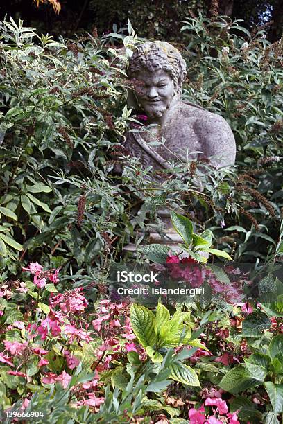 Statua Nel Giardino Tra I Fiori - Fotografie stock e altre immagini di Aiuola - Aiuola, Ambientazione esterna, Ambientazione tranquilla