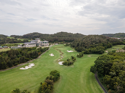 golf course with yellow flag on 18th hole at cloudy sky