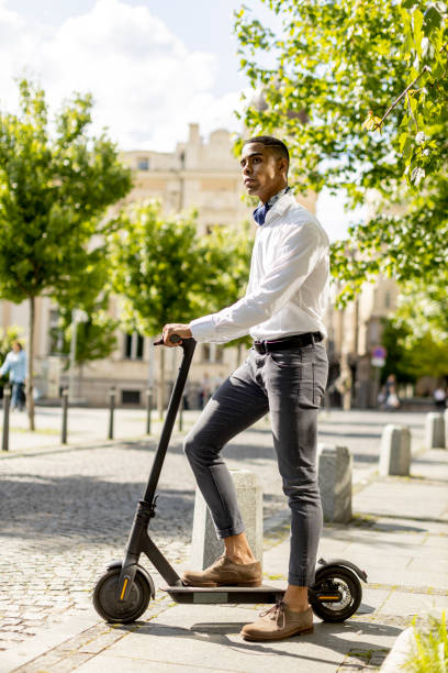 istock Young African American using electric scooter on a street 1396670398