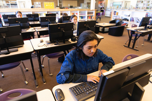 A Navajo male student works on an assignment in the library computer lab. Image taken on the Navajo Reservation, Utah, USA.