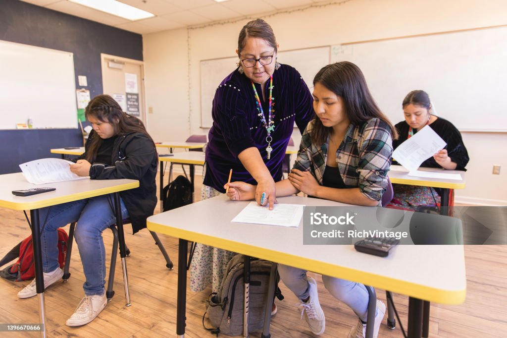 High School Teacher Teaching A Navajo woman and high school teacher teaches math to her students in a classroom. Image taken on the Navajo Reservation, Utah, USA. Indigenous Peoples of the Americas Stock Photo
