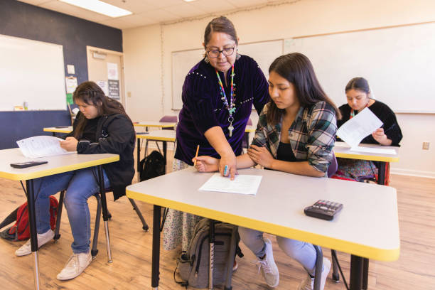 High School Teacher Teaching A Navajo woman and high school teacher teaches math to her students in a classroom. Image taken on the Navajo Reservation, Utah, USA. math teacher stock pictures, royalty-free photos & images