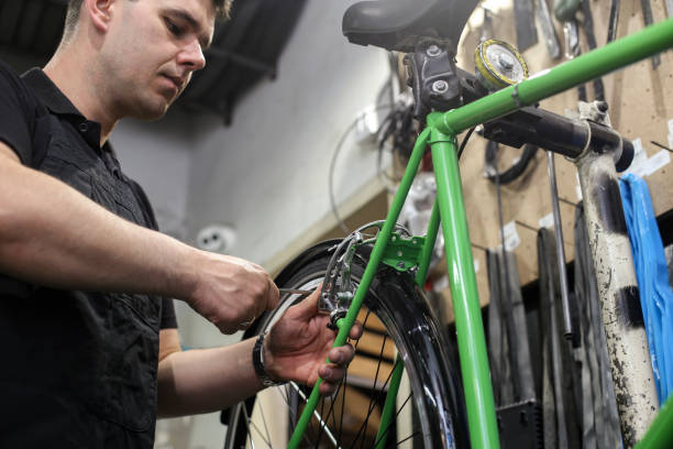 istock Young man working in a bicycle repair shop 1396672754