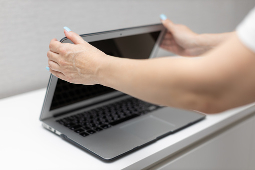 woman closes laptop lid with her hands. High quality photo