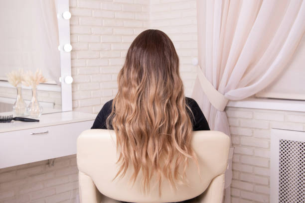 istock Female back with long, curly, brunette hair 1396674933