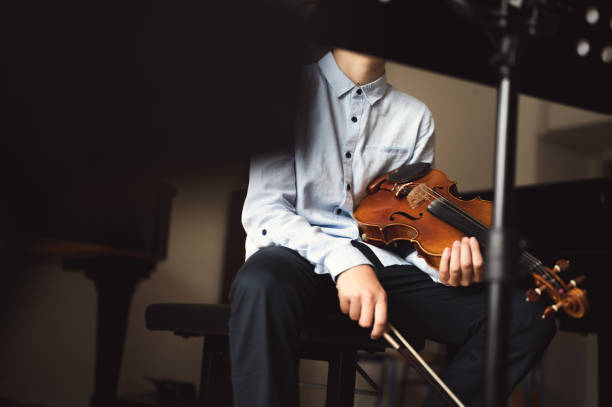 istock Teenager kid student violin player resting indoors 1396677459