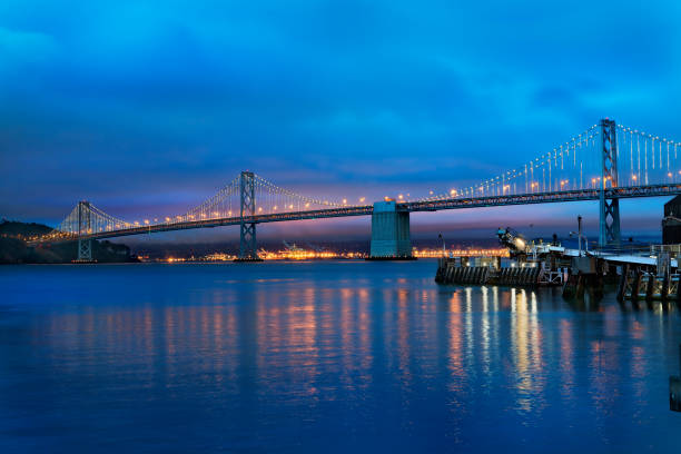 el puente de la bahía de oakland en la bahía de san francisco al atardecer - golden gate bridge night bridge san francisco bay fotografías e imágenes de stock