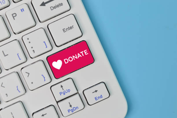 istock Laptop keyboard with text DONATE isolated on a blue background. 1396680406