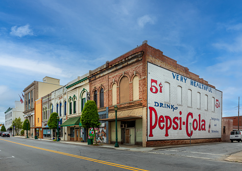 Thomasville, NC, USA-8 May 2022: A block of vintage commercial buildings downtown, with a large painted Pepsi-Cola advertisement on end wall.