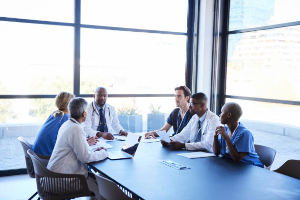 istock Doctors discussing hospital business around a conference table 1396681139