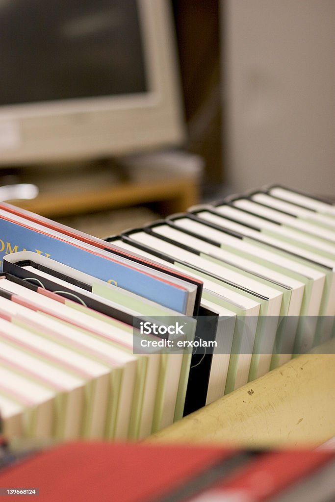 Livres sur une étagère avec ordinateur en arrière-plan - Photo de Bibliothèque libre de droits