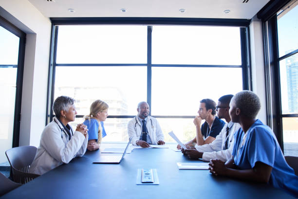 istock Doctors talking together around a hospital conference table 1396681751