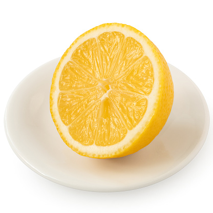 Half of fresh lemon on white ceramic plate isolated on white.