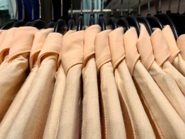 istock Khaki colored clothes hanging in a row 1396683826