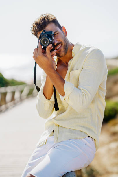 istock Handsome man photographing in a coastal area. 1396684138