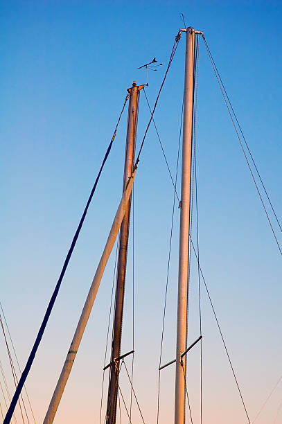 sailboat poles at sunset stock photo