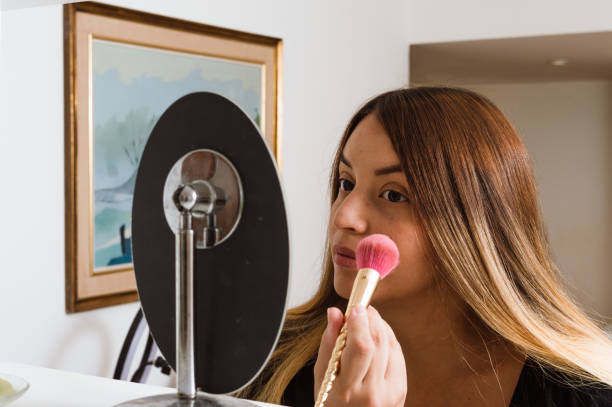 portrait d’une jeune femme caucasienne latine se maquillant pour un rendez-vous amoureux - face powder photos et images de collection