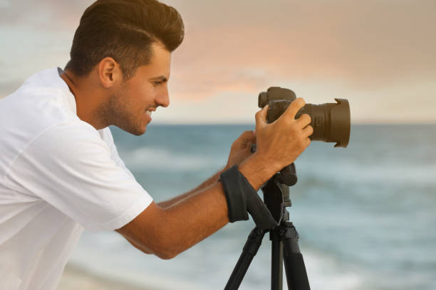 istock Photographer working with professional camera near sea 1396686372