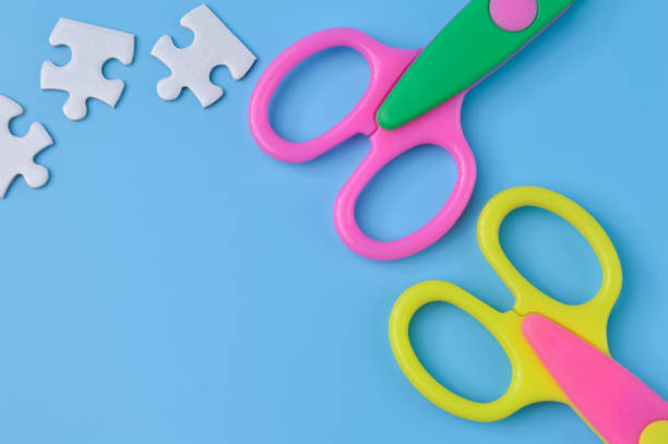 istock Scissors and puzzle isolated on a blue background with copy space 1396686816