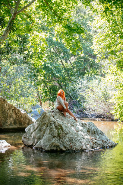 istock Beautiful Redhead Woman in the Untouched River Side Forest 1396688452