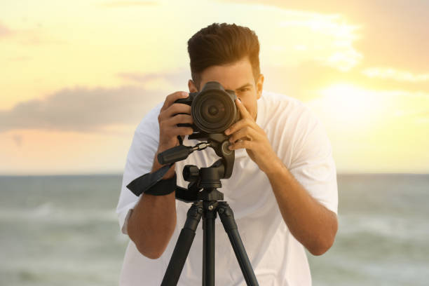 istock Photographer working with professional camera near sea 1396688493