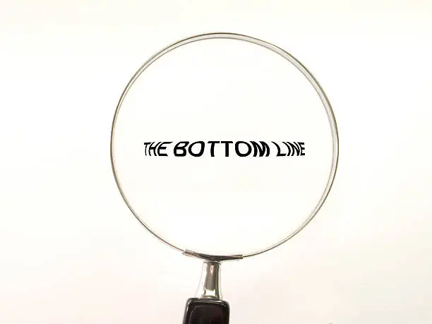 Photo of A magnifying glass over the words 'the bottom line'