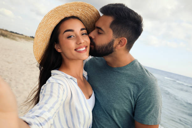 istock Lovely couple taking selfie together on beach 1396688709