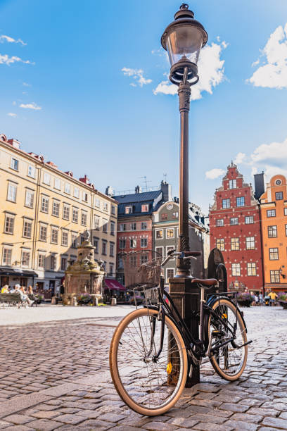 bicycle or bike parked in a cobbled square by a lamppost in stockholm gamla stan. swedish lifestyle or scandinavian preferred transportation vehicle - stockholm gamla stan, sweden - stockholm imagens e fotografias de stock
