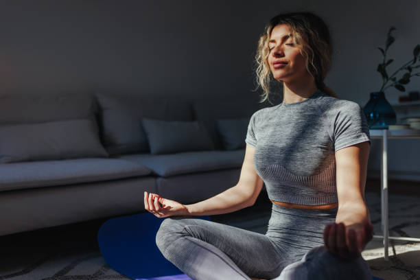 istock Woman meditating in front of window 1396690401