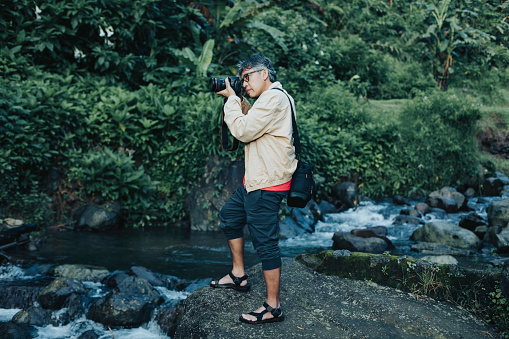 senior adult photographer standing in jungle
