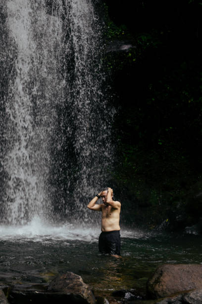 istock Happy Senior man Hiking in the rain forest  and rainfall 1396690779