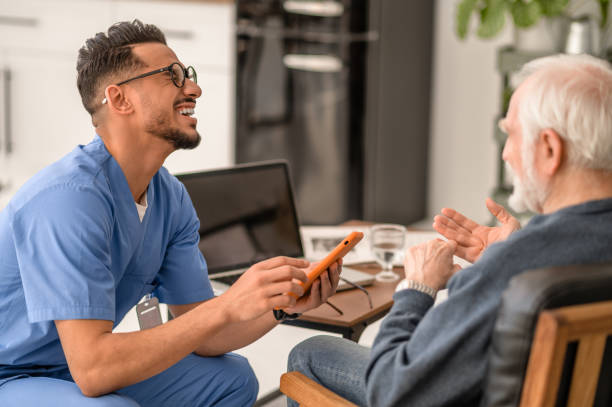 Volunteer enjoying his communication with an aged person stock photo