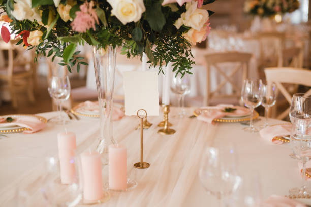 istock Table setting at the wedding reception. Floral compositions with beautiful flowers and greenery, candles, laying and plates on a decorated table. 1396691111