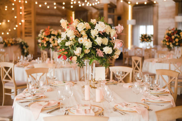 istock Table setting at the wedding reception. Floral compositions with beautiful flowers and greenery, candles, laying and plates on a decorated table. 1396691187