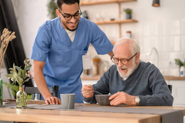 istock Joyous caregiver watching the pensioner eating breakfast 1396691265
