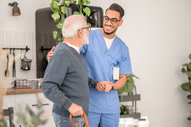 istock Nurse assisting a patient to walk with a walking stick 1396691300