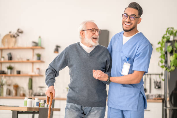 istock Nurse helping his senior patient to walk with a cane 1396691309