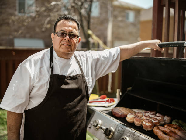 istock Mature Latin Chef grilling meat on BBQ in the backyard 1396691953