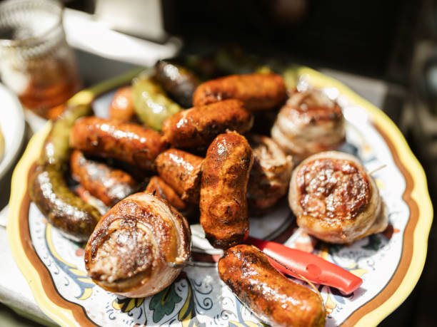 Mexican grilled BBQ meat variety on the platter . Different types of pork and beef meet sorted out and ready to be served. Outdoor grill setting.