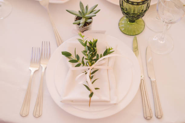Table setting at the wedding reception. Floral compositions with name cards on a vintage plate on a decorated table.