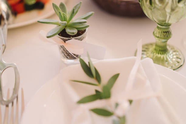 istock Table setting at the wedding reception. Floral compositions with name cards on a vintage plate on a decorated table. 1396692270