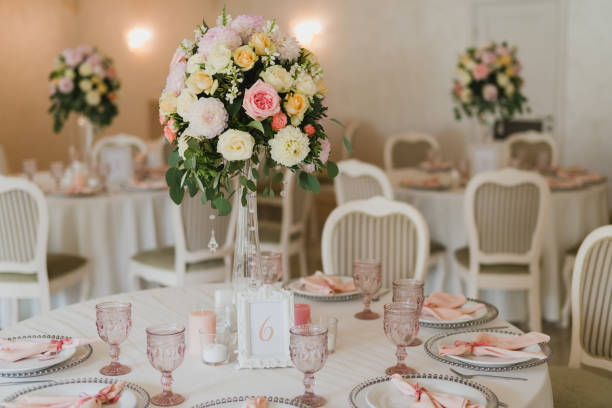 istock Table setting at the wedding reception. Floral compositions with beautiful flowers and greenery, candles, laying and plates on a decorated table. 1396692301