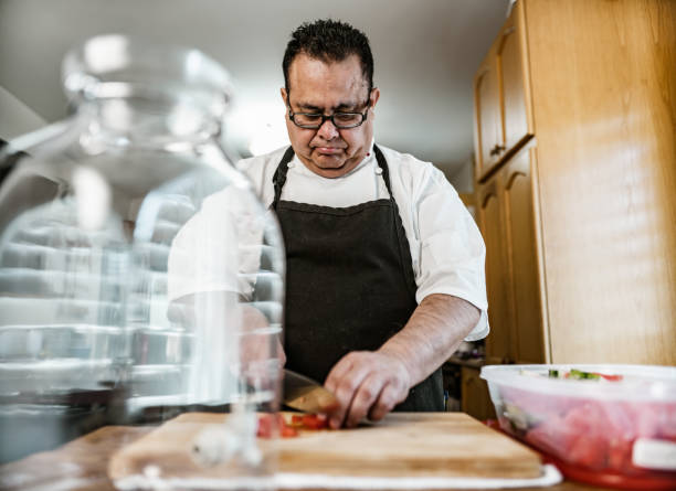 On the grill in restaurant kitchen, senior chef grilling vegetables