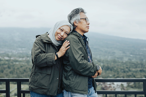 asian mature couple enjoy during traveling with mountain in the background