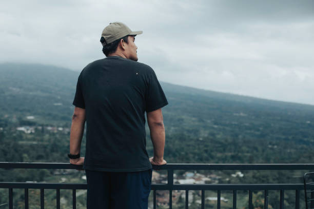 asian man looking merapi mountain in Yogyakarta