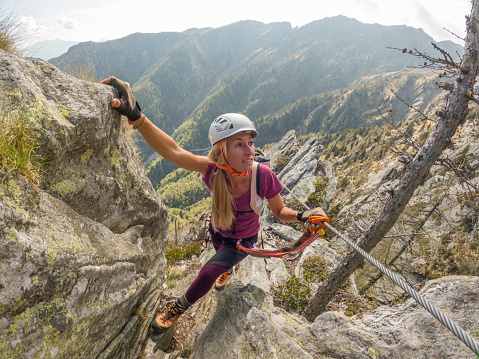 Woman rock climbing on Via Ferrata route