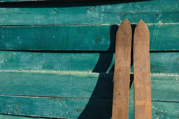 Homemade maple skis .Old technology. Ski socks on a wooden surface of Celadon Green Color on a sunny day in Ukraine. Copy space.