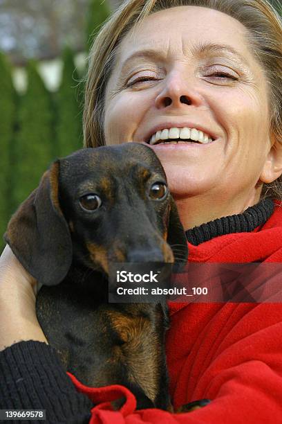 Donna Nei Suoi Anni Cinquanta Con Un Cane - Fotografie stock e altre immagini di 45-49 anni - 45-49 anni, 50-54 anni, Abbracciare una persona
