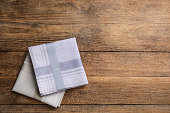 Different handkerchiefs folded on wooden table, flat lay. Space for text